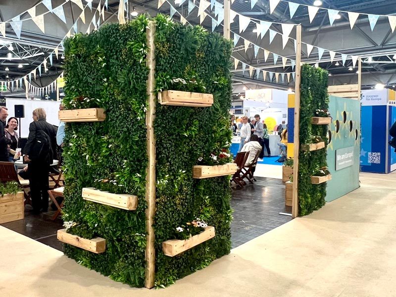 Pflanzenwand mieten Berlin – kabinenartiger Pflanzenwand-Würfel mit grüner Begrünung und Holz-Pflanzkästen auf dem Messestand