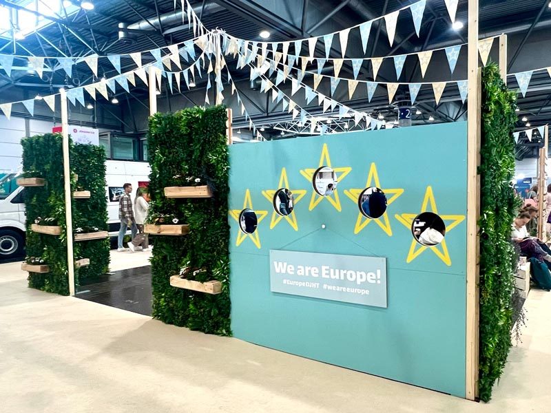 Pflanzenwand mieten Hamburg – grüne Pflanzenwand mit Holz-Pflanzregalen rahmt einen Messestand ein