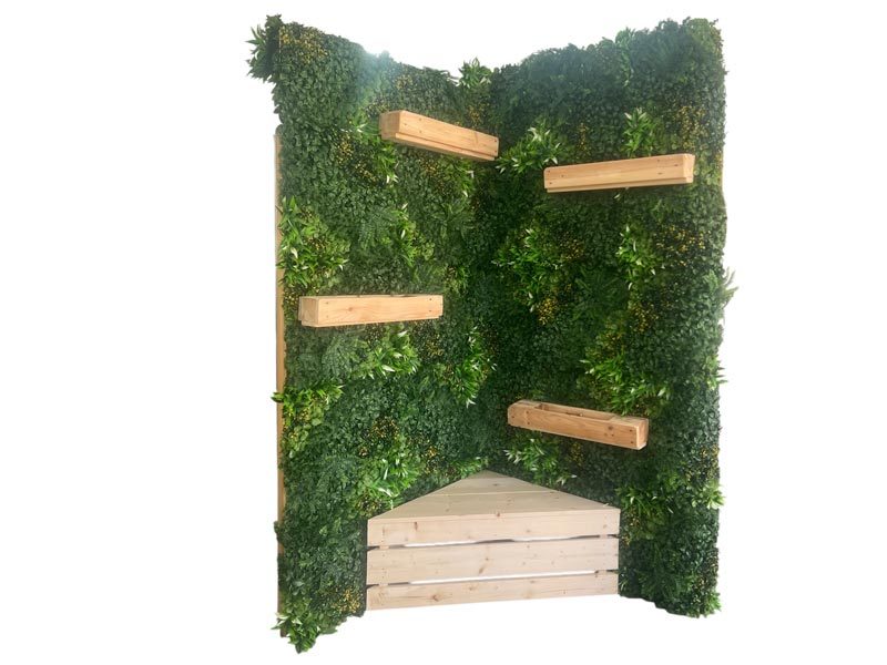 Pflanzenwand mieten Leipzig – freistehende Pflanzenwand-Ecke mit dichter Kunstpflanzen-Begrünung, Holz-Pflanzregalen und integrierter Sitzbank
